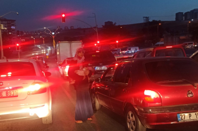 TRAFİK IŞIKLARINDA DİLENCİ KADIN BEBEĞİNİ TEHLİKEYE ATTI .